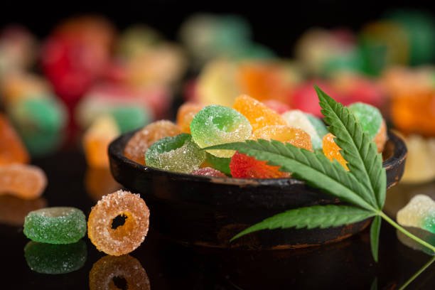 Close-up photo of colorful Delta 9 THC gummies with cannabis leaves, representing legal hemp-derived edibles.